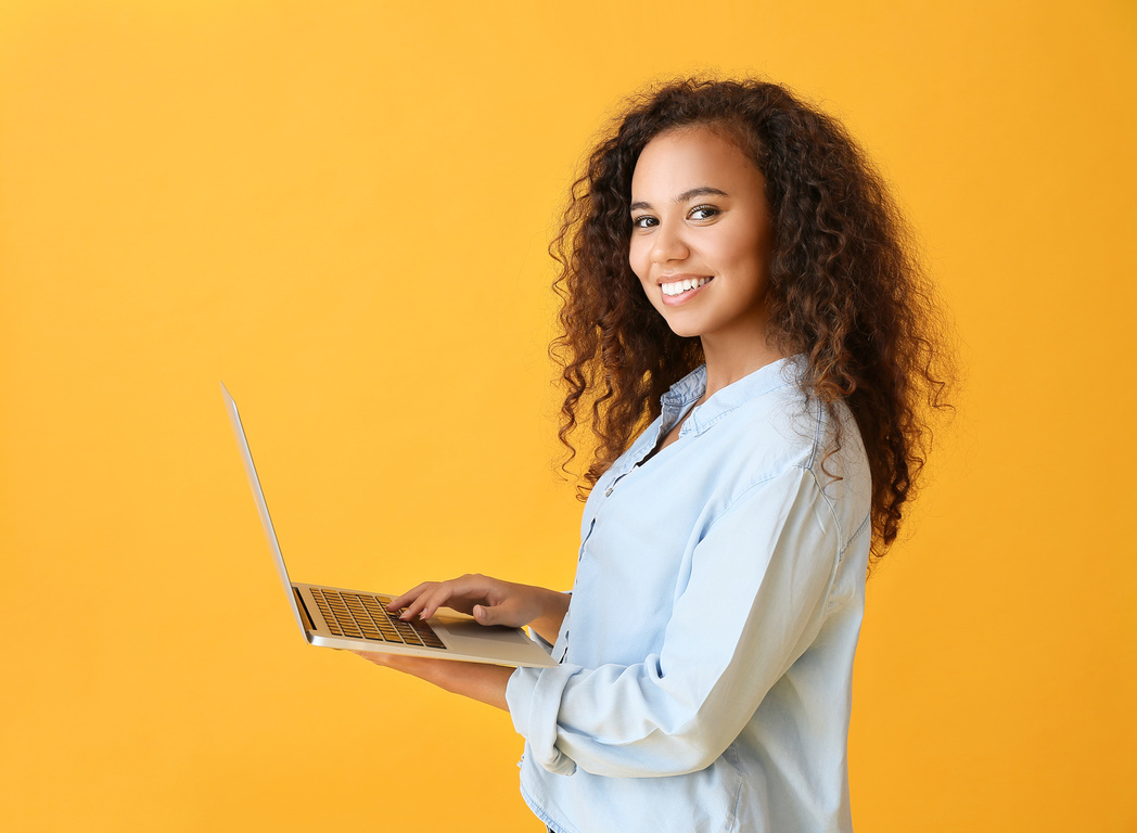 Young Woman with Laptop on Color Background
