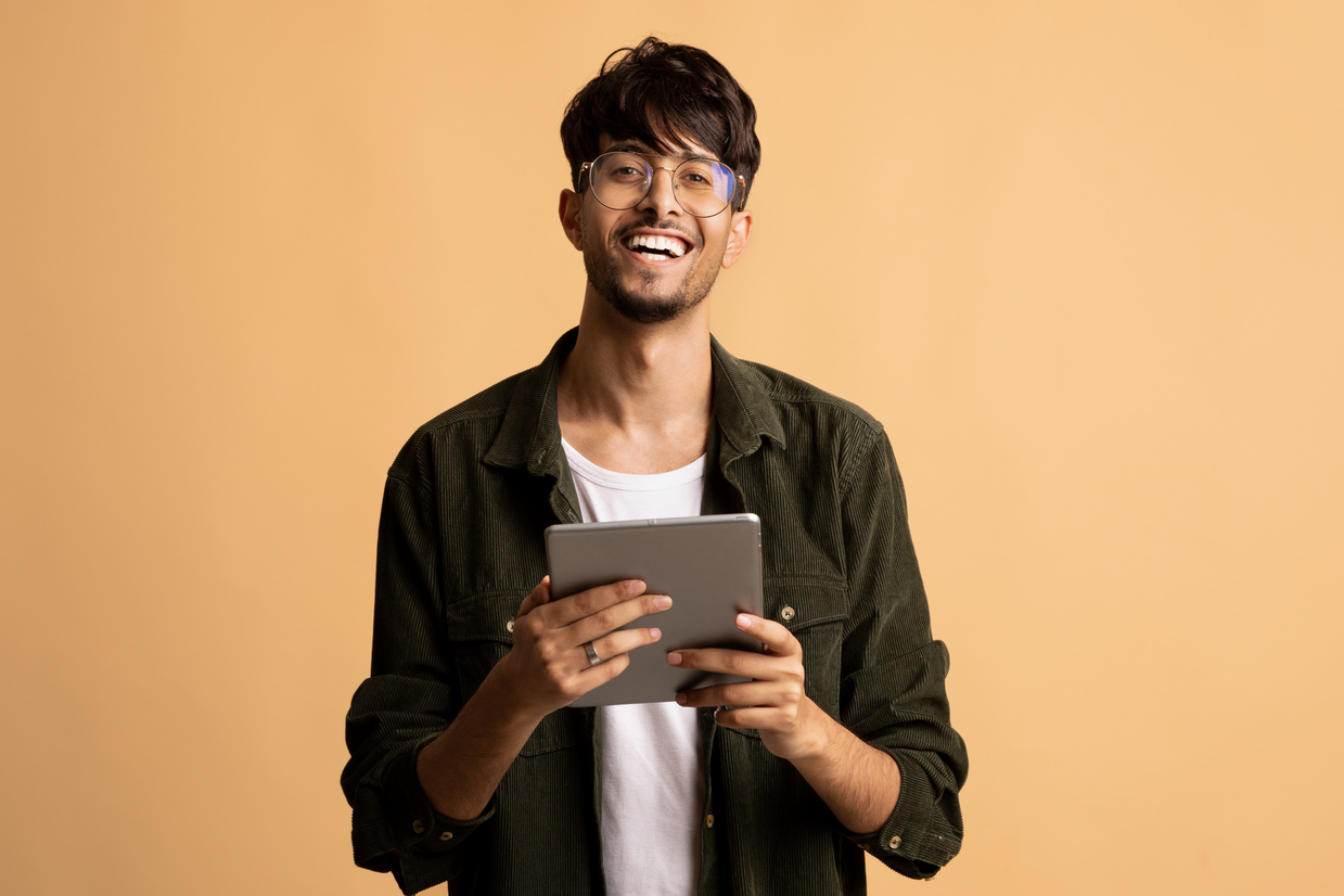 Happy Indian Guy Freelancer Using Modern Digital Tablet